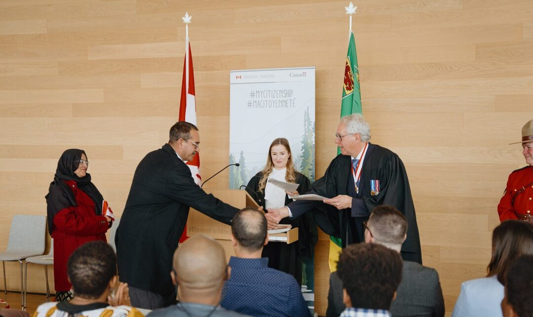 People shaking hands at a citizenship ceremony.