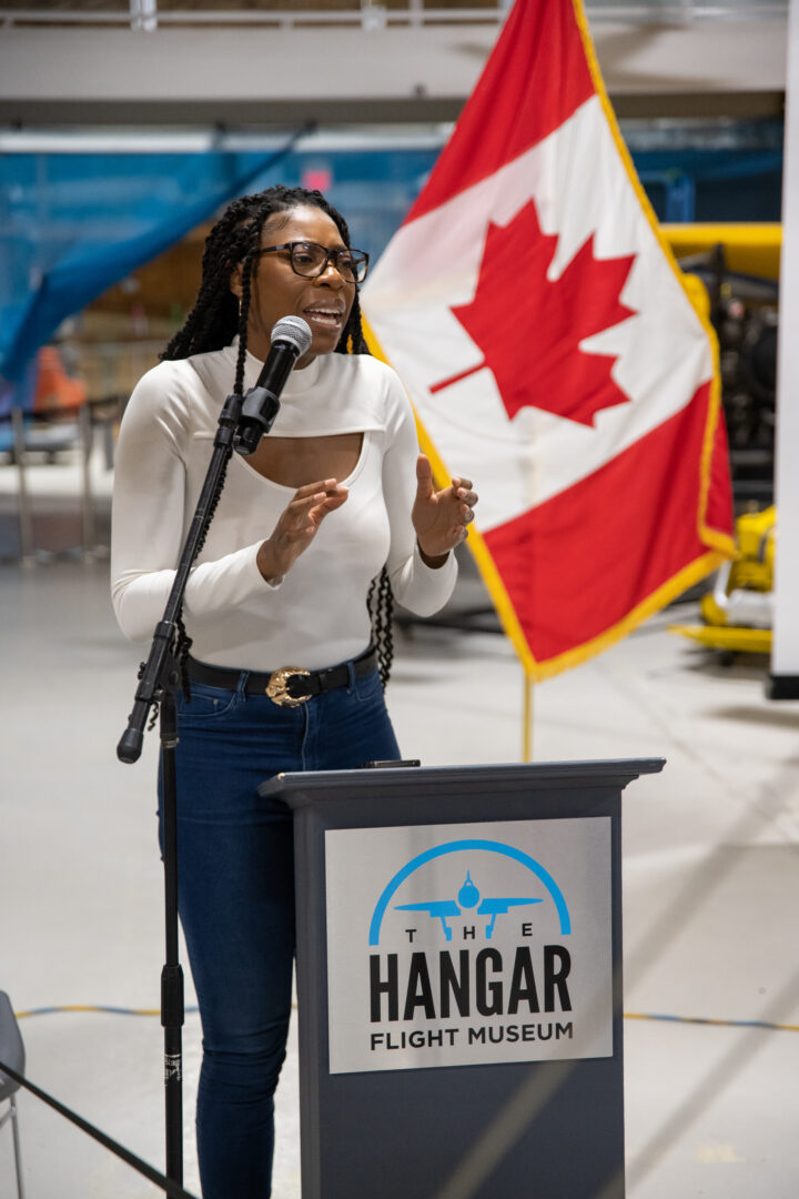 Priscille Buckahsa performing in front of a Canadian flag.