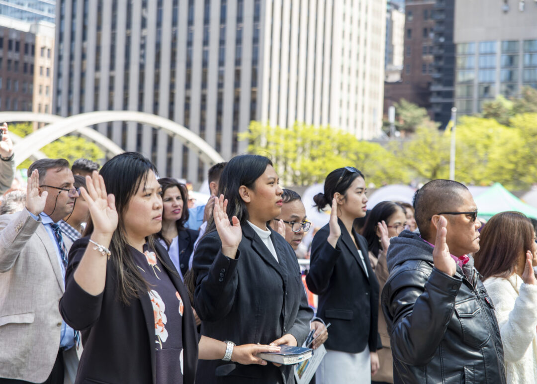 People taking the Canadian oath of citizenship in Nathan Phillips Square.