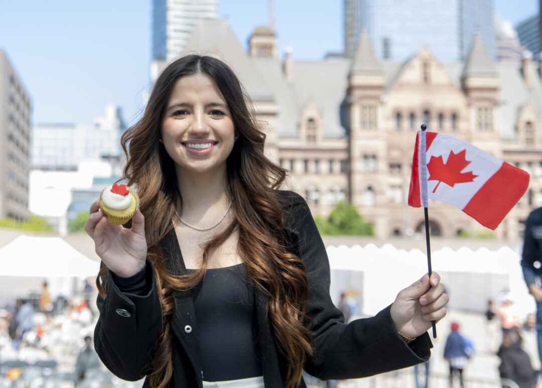 Woman with cupcake and Canadian flag in Nathan Phillips Square